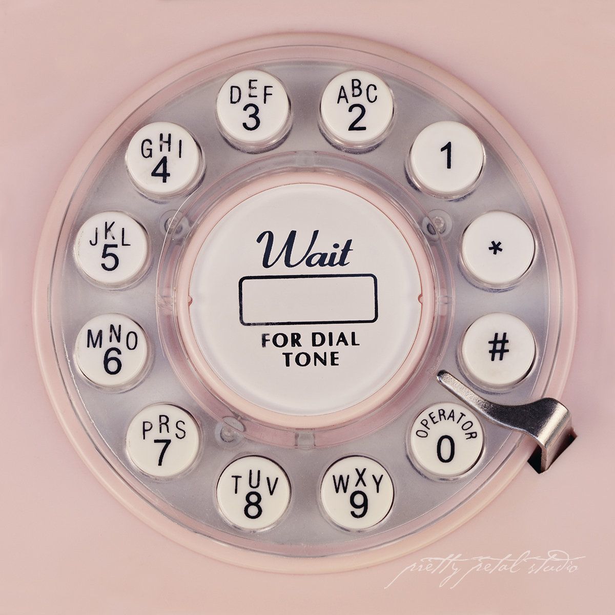 vintage pink rotary phone dial with the words 'Wait for dial tone' in script
